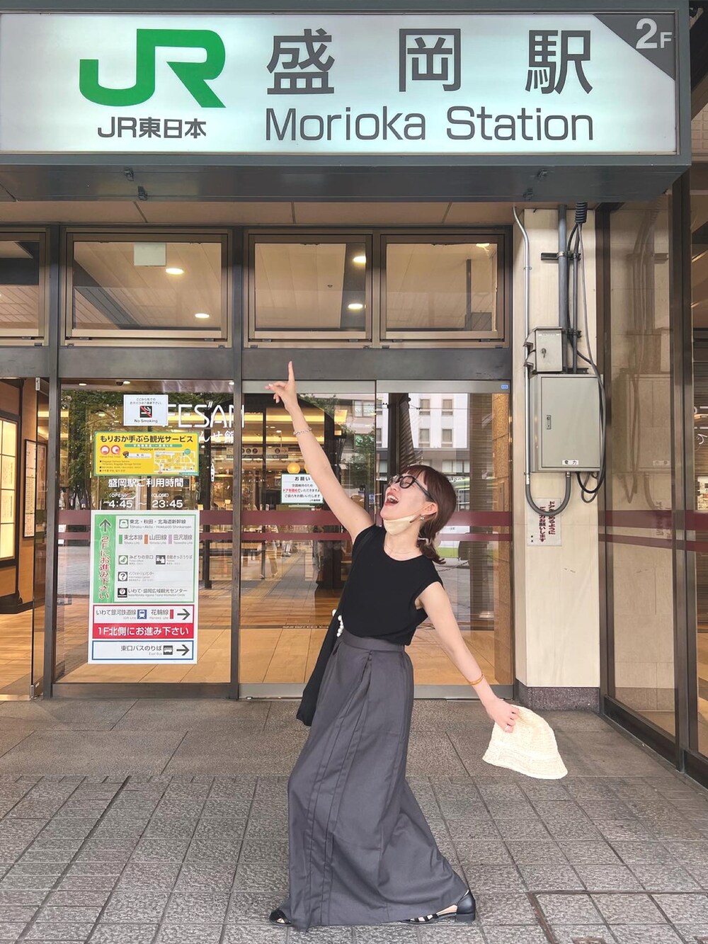 グレー系のスカート、ブラック系のTシャツ/カットソー、ブラウン系のメガネを着用したレディースの夏コーディネートの2枚目の写真