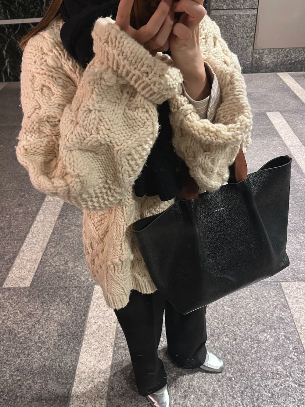 ホワイト系のニット/セーター、ブラック系のハンドバッグ、ホワイト系のスニーカーを着用したレディースの冬コーディネートの5枚目の写真