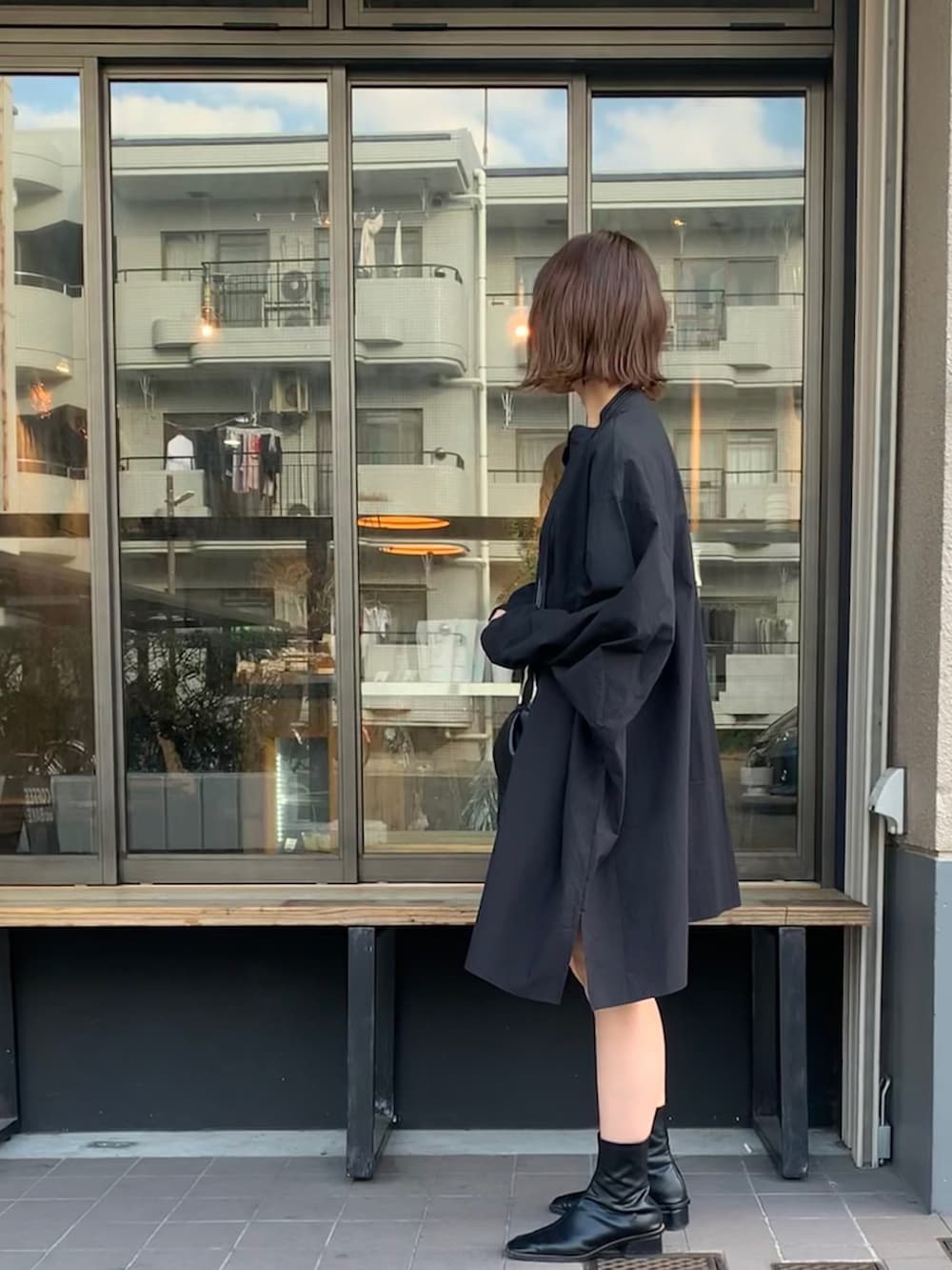 ブラック系のシャツ/ブラウス、ブラック系のショルダーバッグ、ブラック系のブーツを着用したレディースの春コーディネートの2枚目の写真