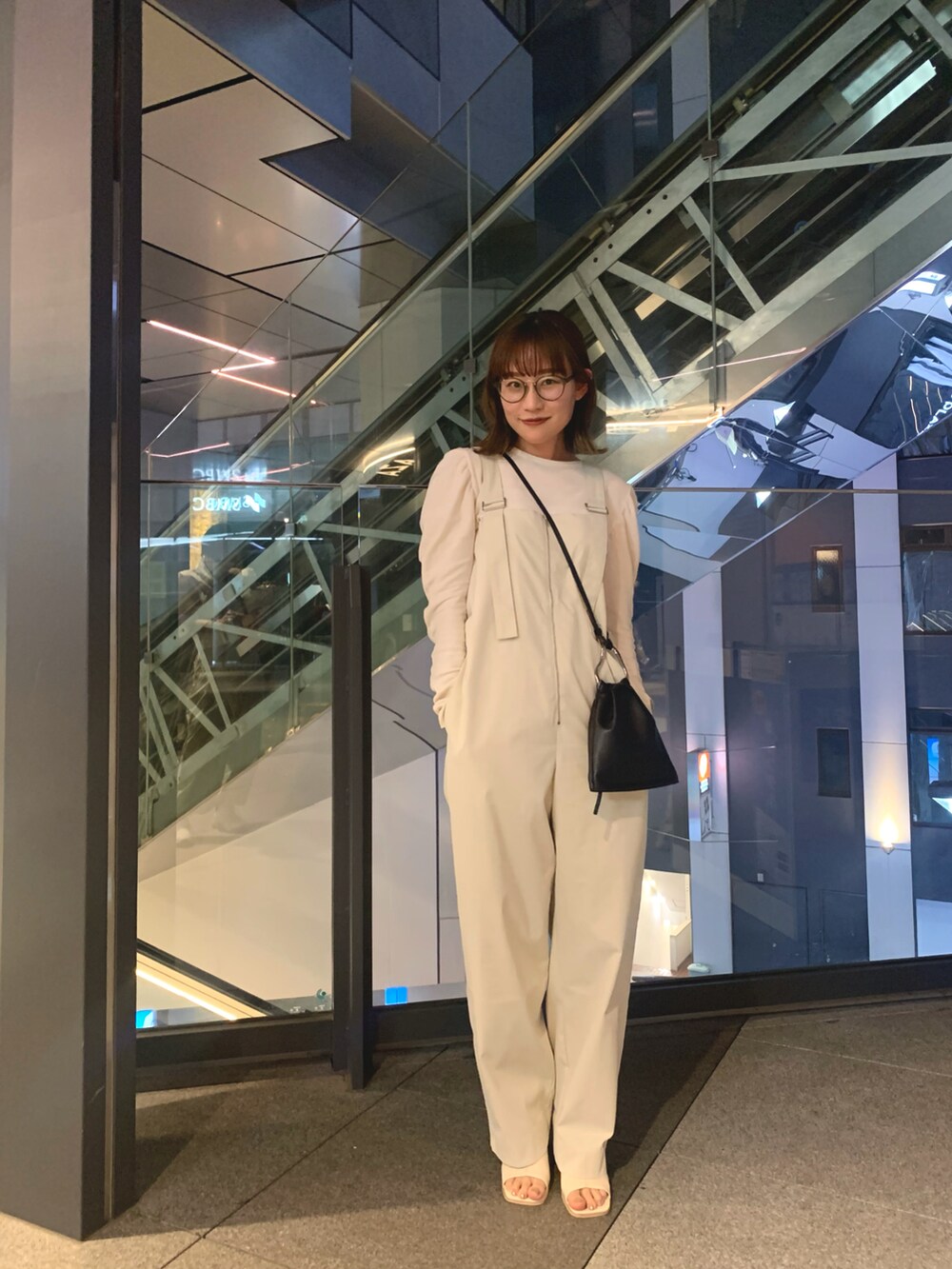 ホワイト系のTシャツ/カットソー、ホワイト系のサロペット/オーバーオール、ブラック系のショルダーバッグを着用したレディースの夏コーディネートの3枚目の写真