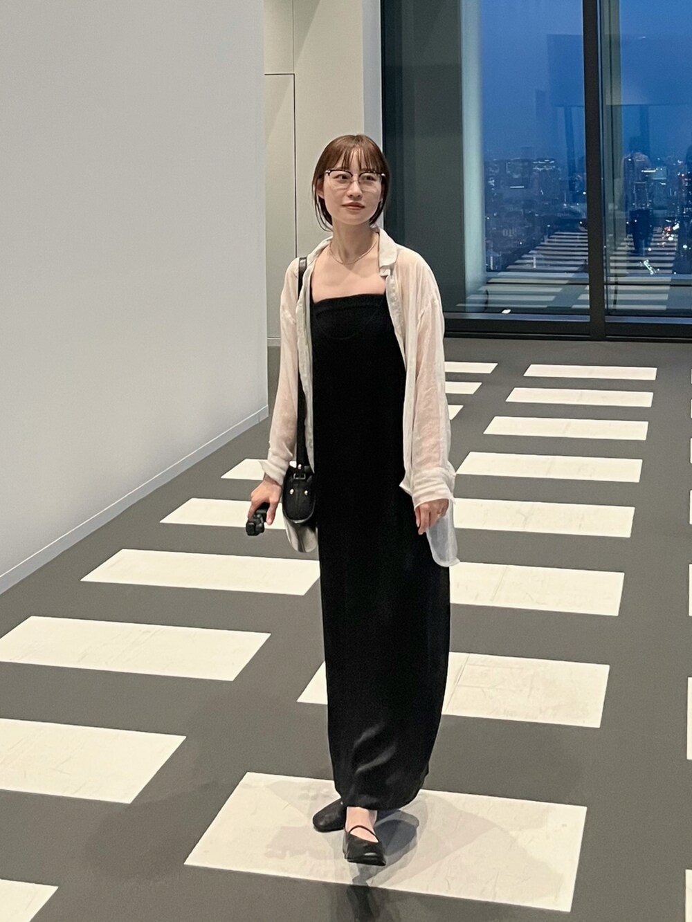 ブラック系のワンピース、ブラック系のショルダーバッグ、ブラック系のチューブトップを着用したレディースの秋コーディネートの2枚目の写真