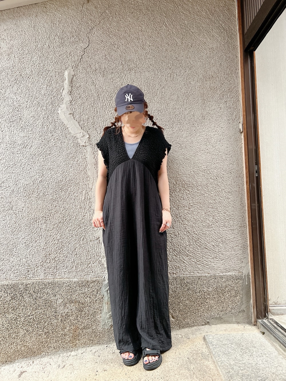 ブルー系のカーディガン/ボレロ、ブラック系のつなぎ/オールインワン、ブラック系のサンダルを着用したレディースの秋コーディネートの2枚目の写真