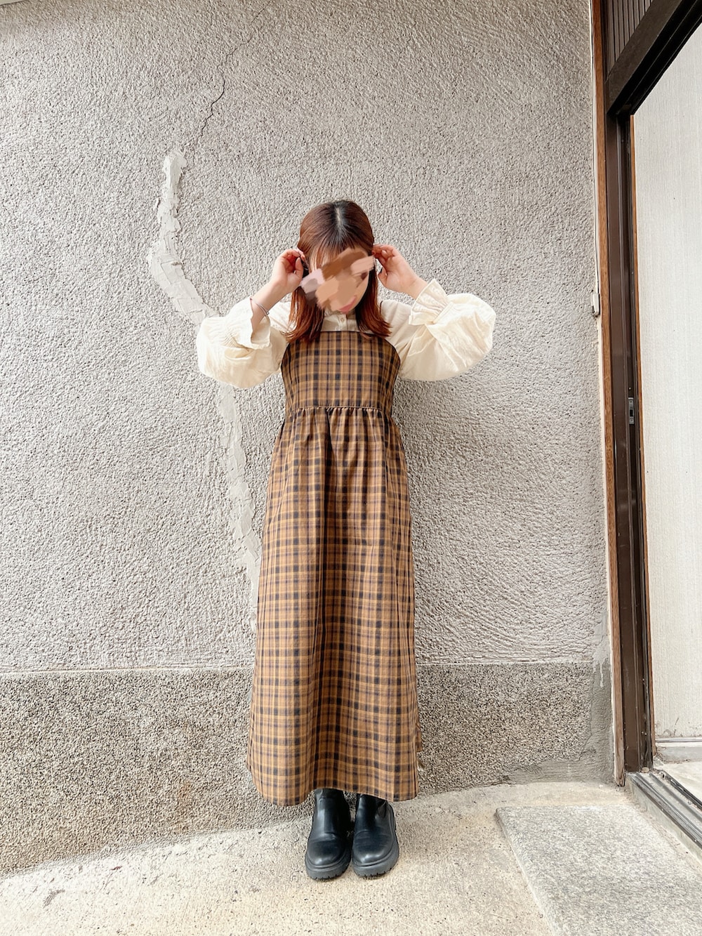 ホワイト系のノーカラージャケット、ブラウン系のワンピースを着用したレディースの春コーディネートの2枚目の写真