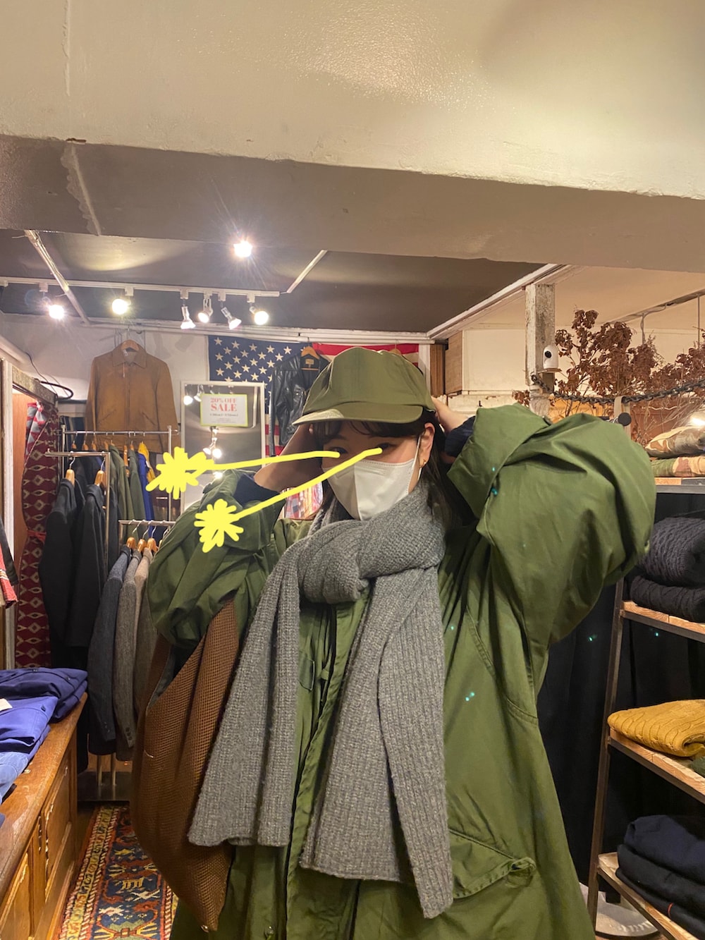 ブラウン系のバッグ、グリーン系のモッズコート、ブラック系のカーゴパンツを着用したレディースの冬コーディネートの2枚目の写真