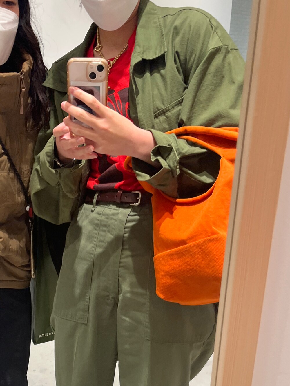 グリーン系のミリタリージャケット、グリーン系のカーゴパンツ、ベージュ系のローファーを着用したレディースの秋コーディネートの2枚目の写真