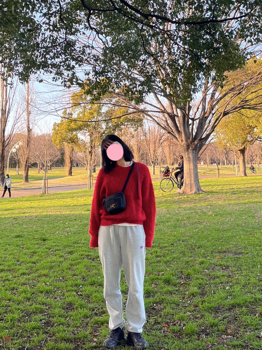 レッド系のニット/セーター、グレー系のスウェットパンツを着用したレディースの冬コーディネートの2枚目の写真