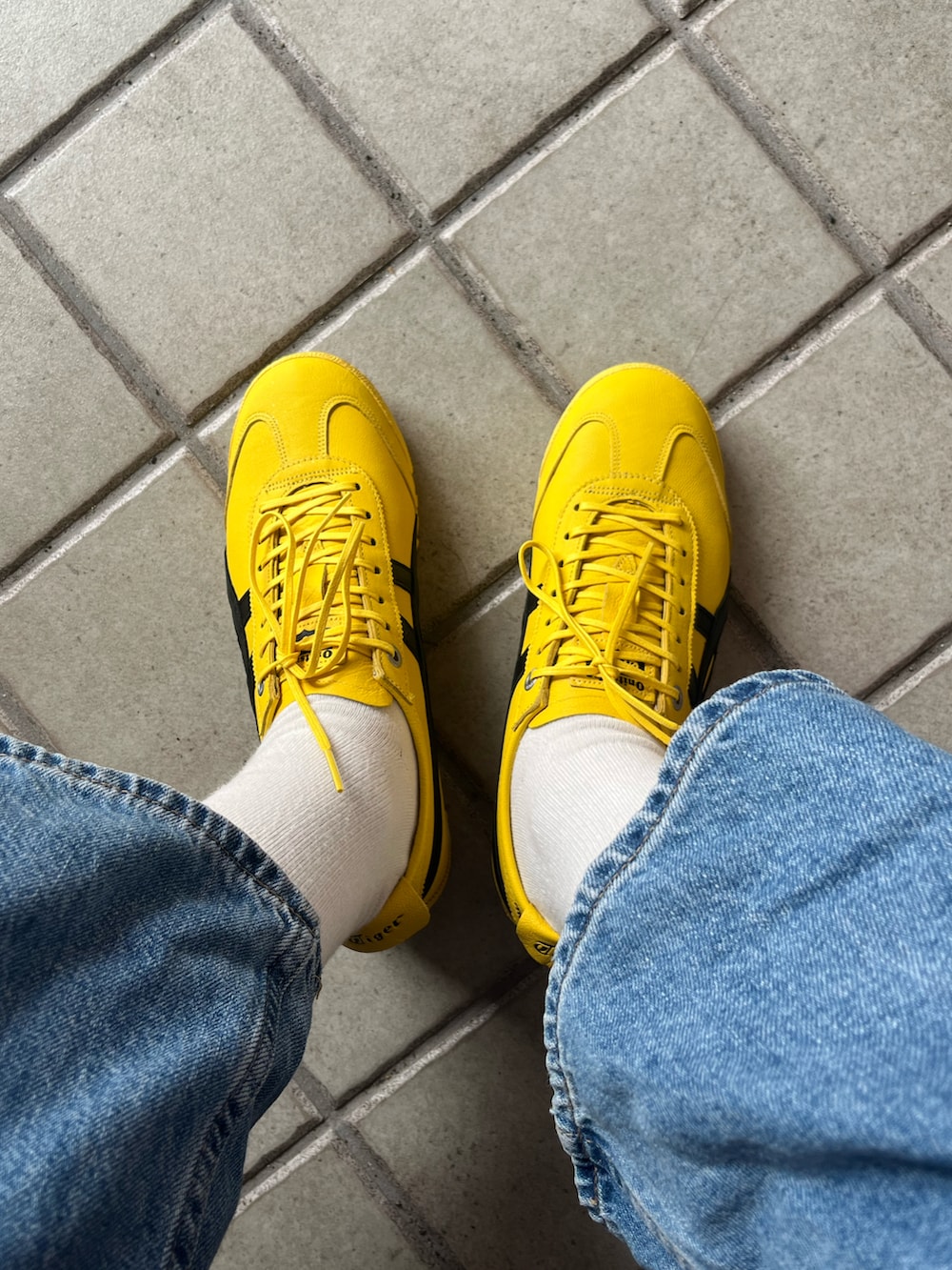 イエロー系のスニーカーを着用したレディースの春コーディネートの2枚目の写真