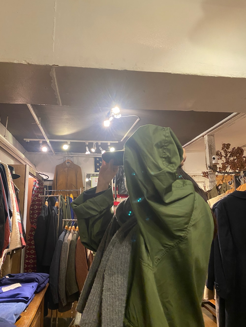 ブラウン系のバッグ、グリーン系のモッズコート、ブラック系のカーゴパンツを着用したレディースの冬コーディネートの3枚目の写真