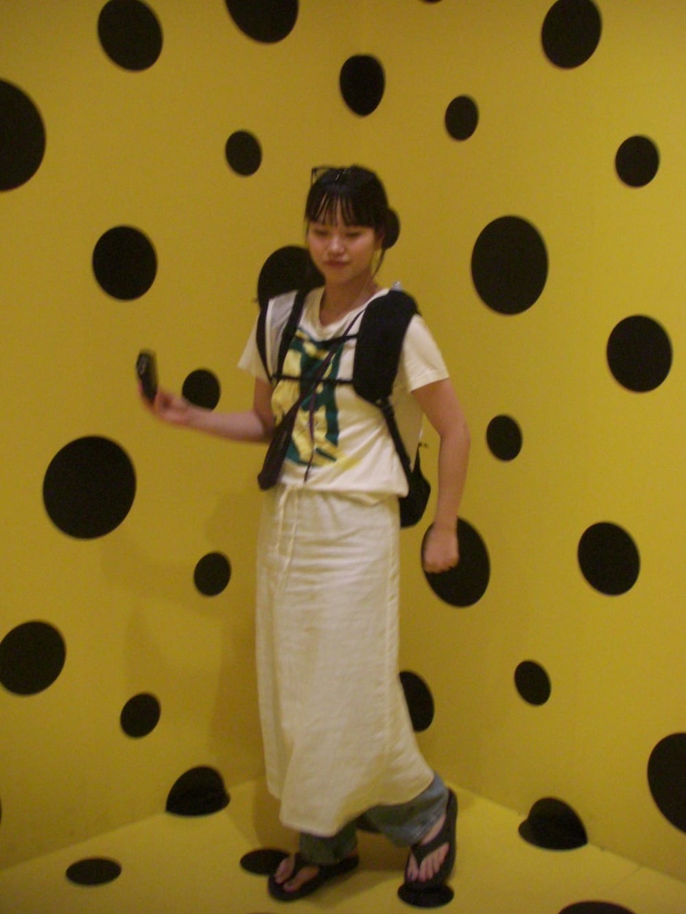 ホワイト系のスカート、ホワイト系のTシャツ/カットソー、ブラック系のサンダルを着用したレディースの夏コーディネートの2枚目の写真