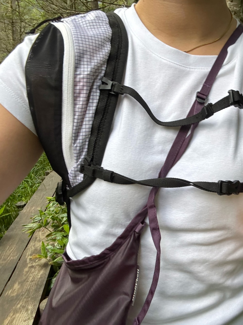 ブラック系のスニーカー、ホワイト系のバックパック/リュック、パープル系のバッグを着用したレディースの夏コーディネートの4枚目の写真