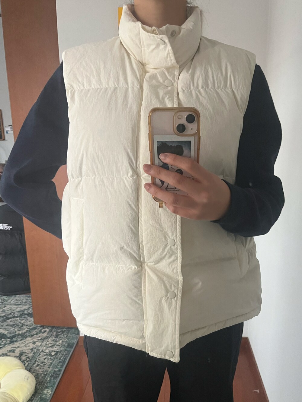 ホワイト系のダウンベストを着用したレディースの冬コーディネートの2枚目の写真