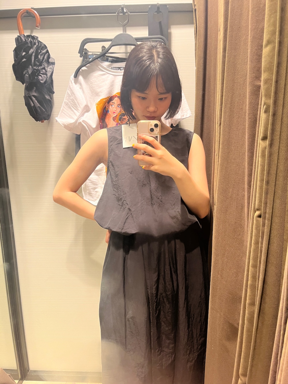 ブラック系のスカート、ブラック系のタンクトップ、レッド系のスニーカーを着用したレディースの夏コーディネートの4枚目の写真