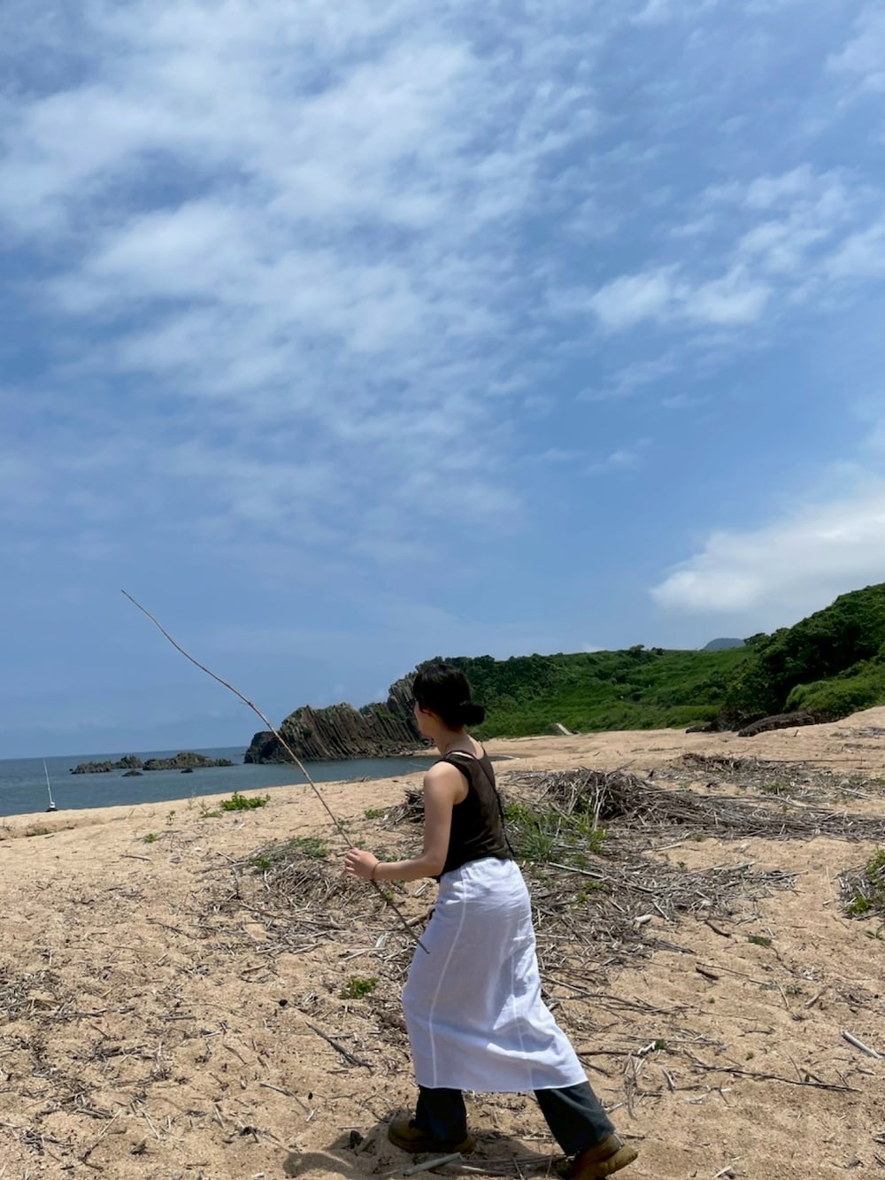 ホワイト系のスカート、パープル系のショルダーバッグ、ベージュ系のスニーカーを着用したレディースの夏コーディネートの3枚目の写真