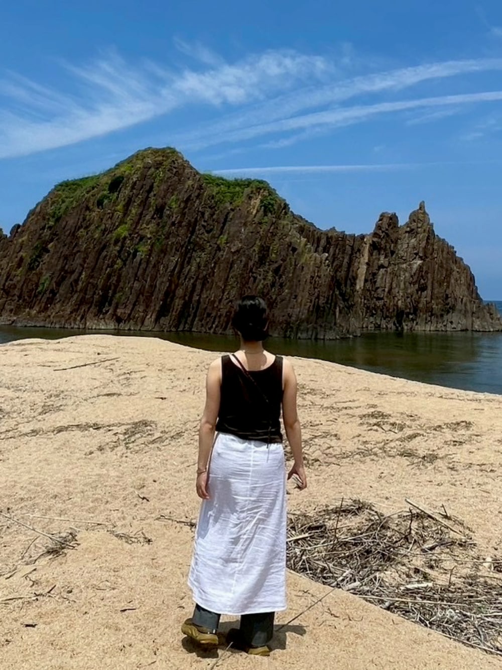 ホワイト系のスカート、パープル系のショルダーバッグ、ベージュ系のスニーカーを着用したレディースの夏コーディネートの2枚目の写真