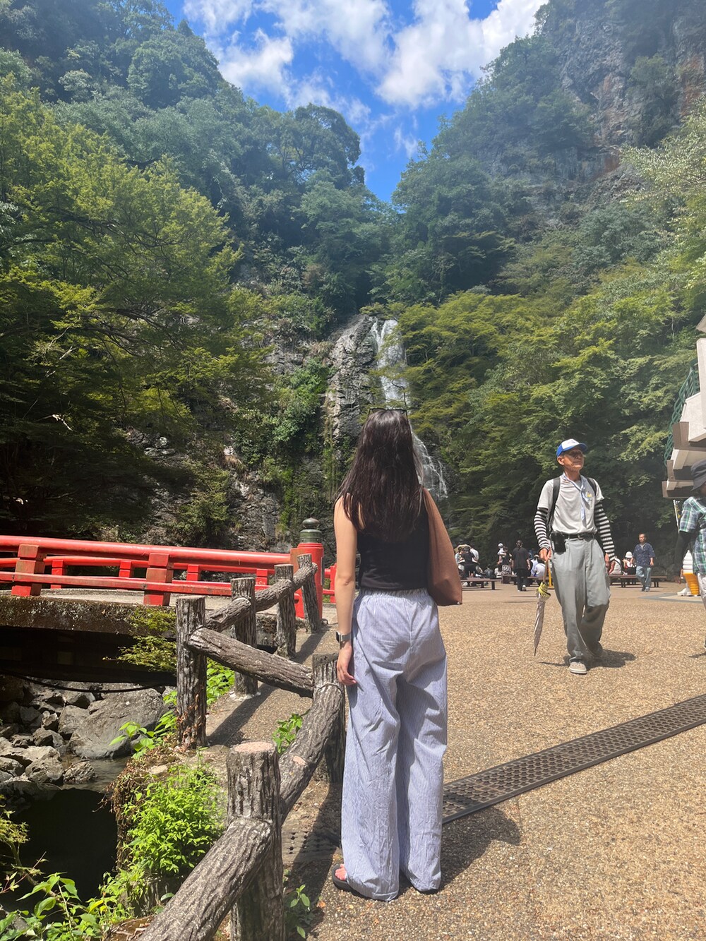 ブラック系のタンクトップ、ブルー系のその他パンツ、ブラック系のサンダルを着用したレディースの夏コーディネートの2枚目の写真