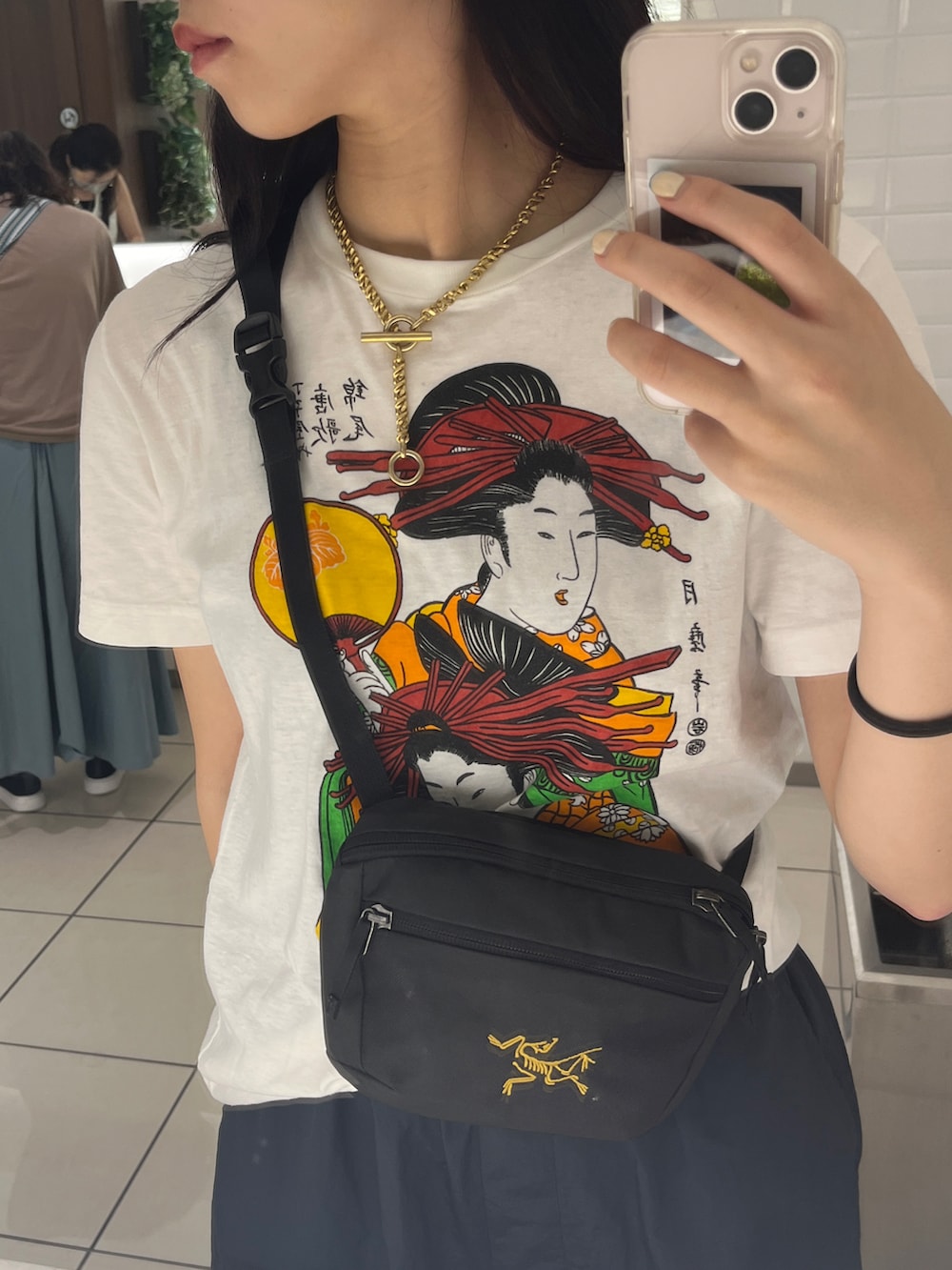 ブラック系のカーゴパンツ、ホワイト系のTシャツ/カットソー、ブラック系のショルダーバッグを着用したレディースの夏コーディネートの2枚目の写真