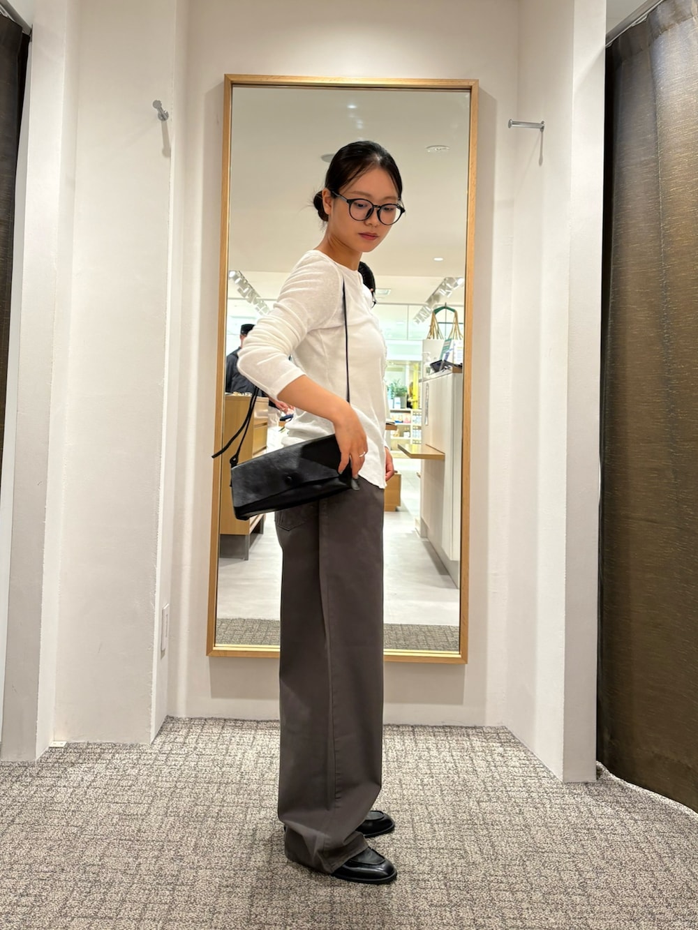 ホワイト系のTシャツ/カットソー、グレー系のその他パンツ、ブラック系のローファーを着用したレディースの夏コーディネートの2枚目の写真