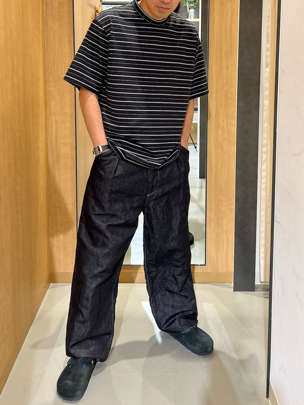ブラック系のTシャツ/カットソー、ブラック系のデニムパンツ、ブラック系のサンダルを着用したメンズの夏コーディネートの2枚目の写真