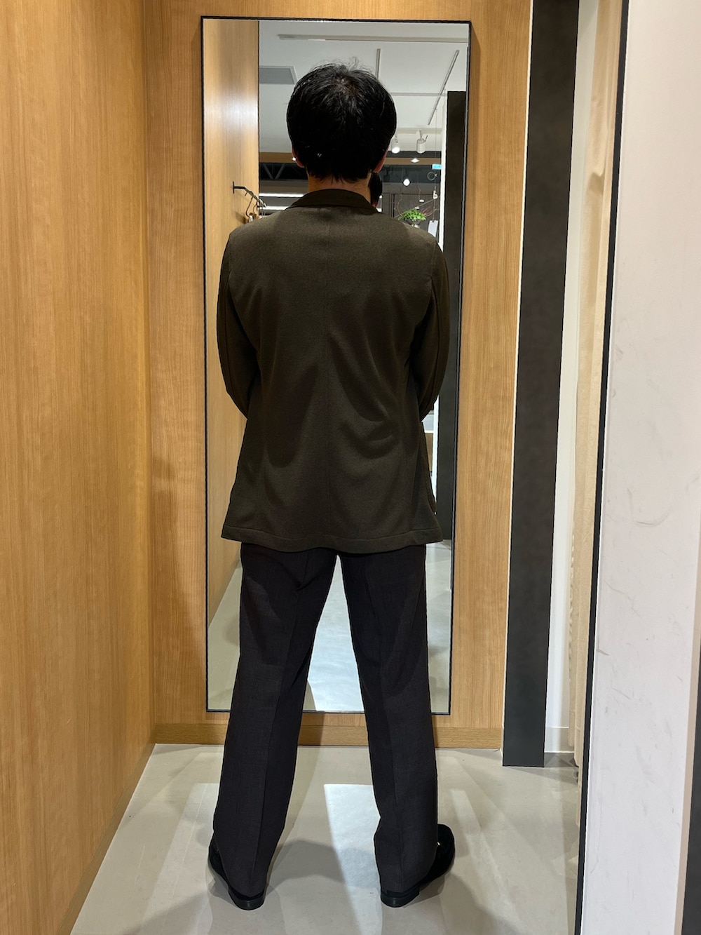 ホワイト系のシャツ/ブラウス、ブラウン系のスーツパンツ、ブラック系のドレスシューズを着用したメンズの春コーディネートの3枚目の写真