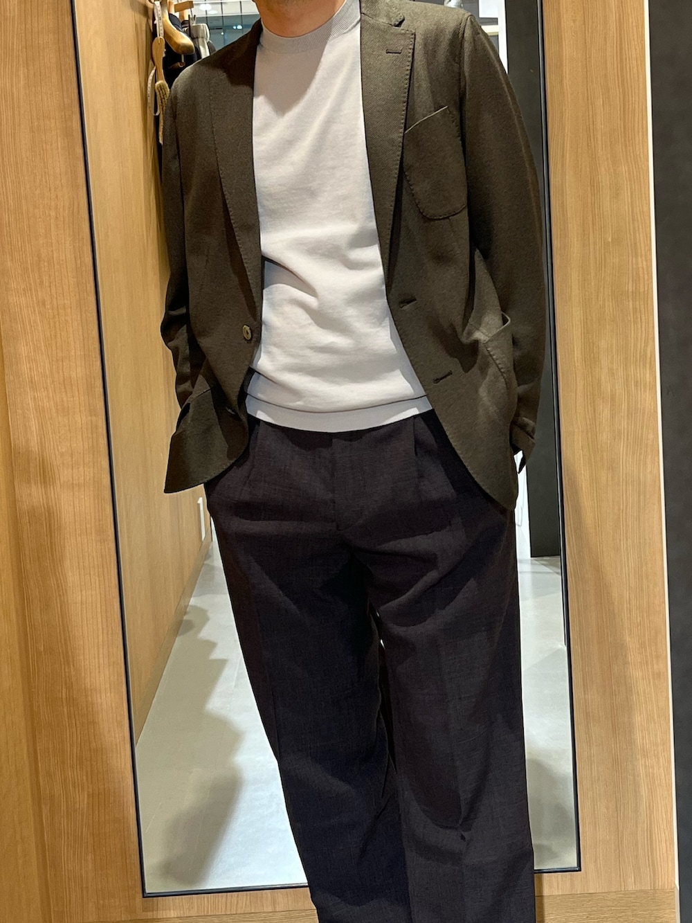 ホワイト系のシャツ/ブラウス、ブラウン系のスーツパンツ、ブラック系のドレスシューズを着用したメンズの春コーディネートの2枚目の写真