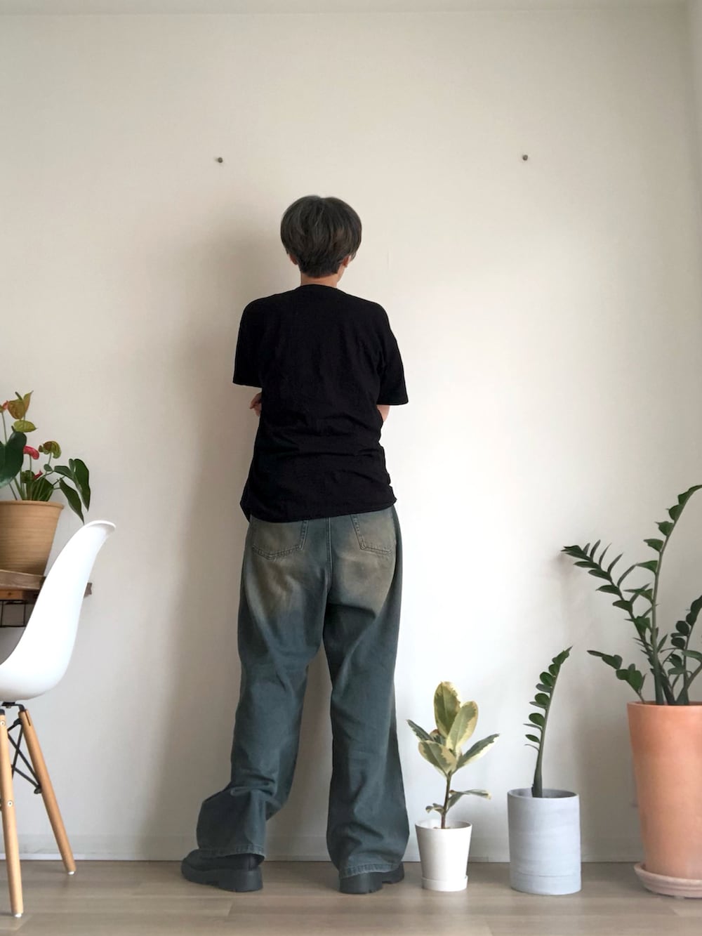 ブラック系のブーツ、ブラック系のTシャツ/カットソー、ブルー系のデニムパンツを着用したレディースの秋コーディネートの2枚目の写真