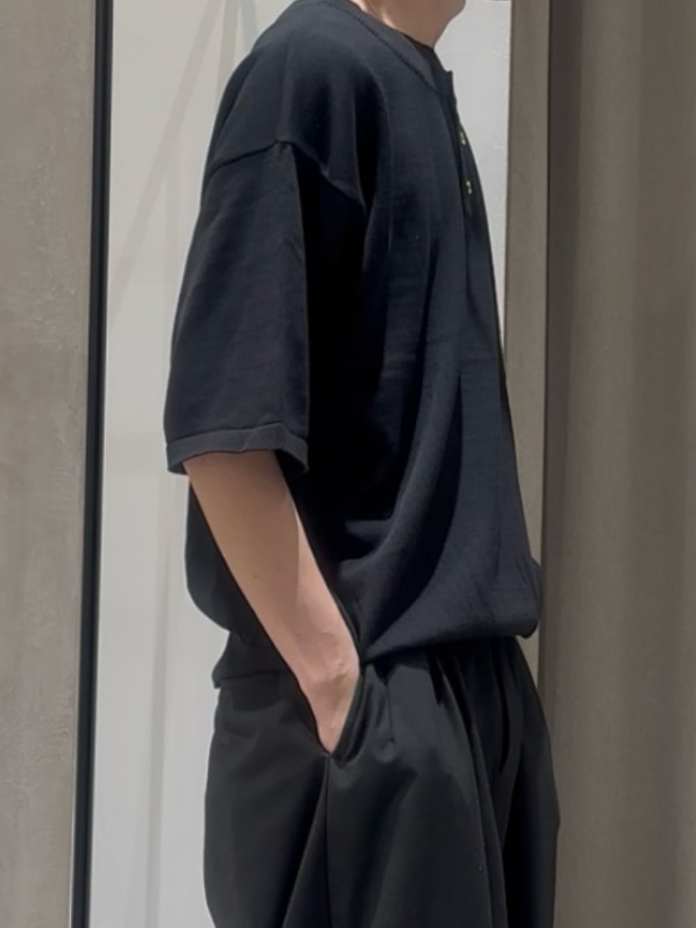 ブラック系のTシャツ/カットソー、ブラック系のスラックスを着用したメンズの春コーディネートの4枚目の写真