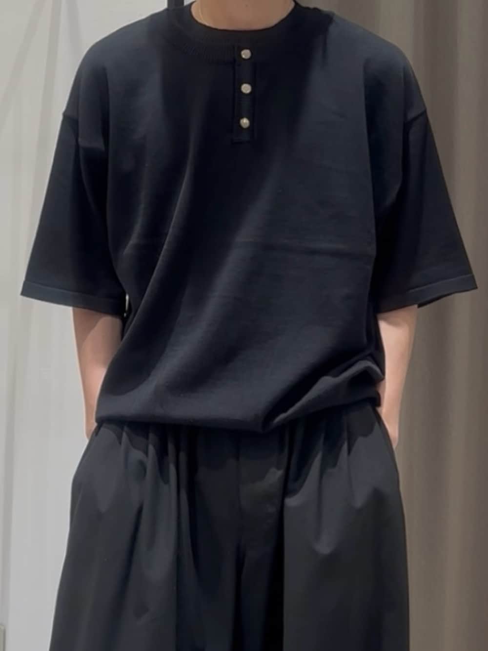 ブラック系のTシャツ/カットソー、ブラック系のスラックスを着用したメンズの春コーディネートの3枚目の写真