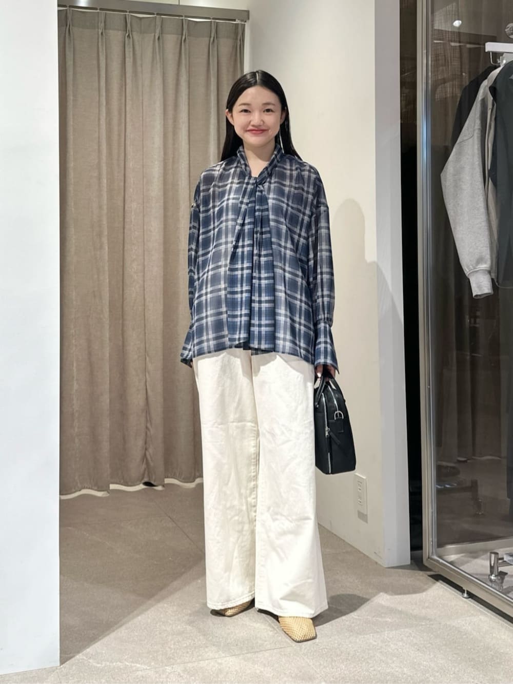 ホワイト系のデニムパンツ、ベージュ系のその他シューズ、ブラック系のショルダーバッグを着用したレディースの夏コーディネートの4枚目の写真