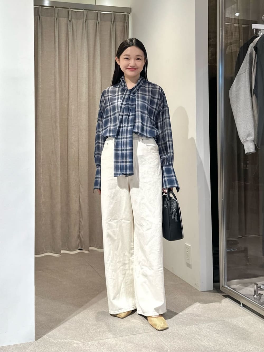 ホワイト系のデニムパンツ、ベージュ系のその他シューズ、ブラック系のショルダーバッグを着用したレディースの夏コーディネートの3枚目の写真