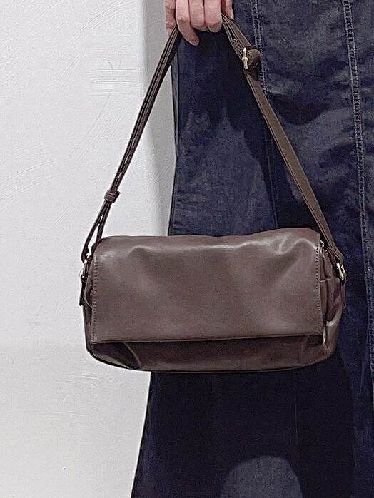 レッド系のカーディガン/ボレロ、ブラック系のデニムスカート、ブラウン系のブーツを着用したレディースの秋コーディネートの8枚目の写真