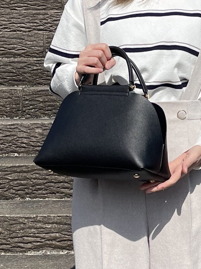 ホワイト系のニット/セーター、ベージュ系のその他パンツ、ブラック系のハンドバッグを着用したレディースの冬コーディネートの10枚目の写真