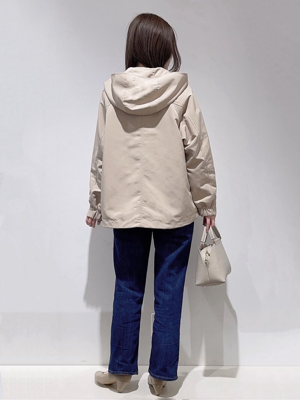 ベージュ系のブルゾン、ブルー系のカーディガン/ボレロ、ホワイト系のTシャツ/カットソーを着用したレディースの春コーディネートの3枚目の写真