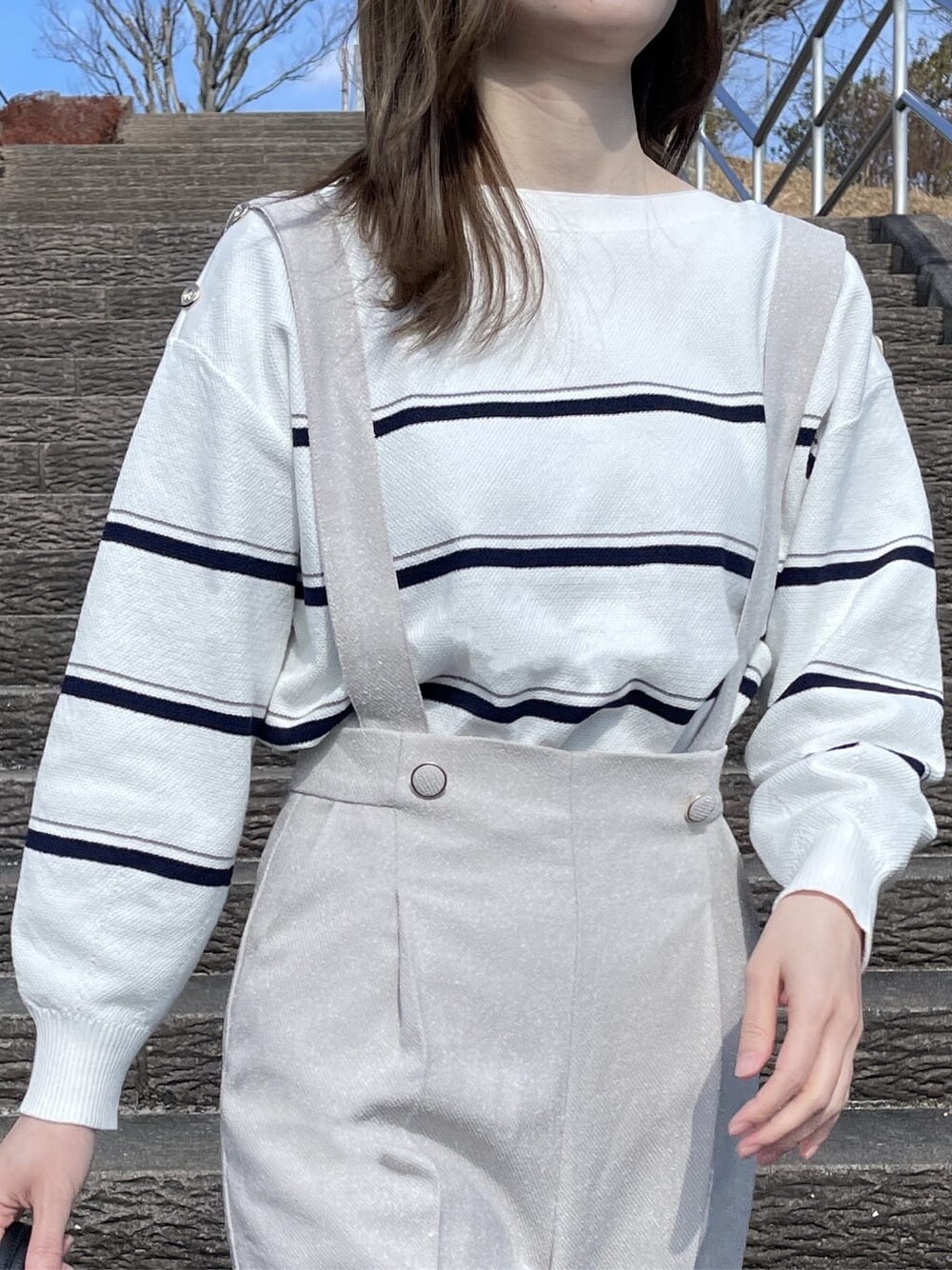 ホワイト系のニット/セーター、ベージュ系のその他パンツ、ブラック系のハンドバッグを着用したレディースの冬コーディネートの6枚目の写真