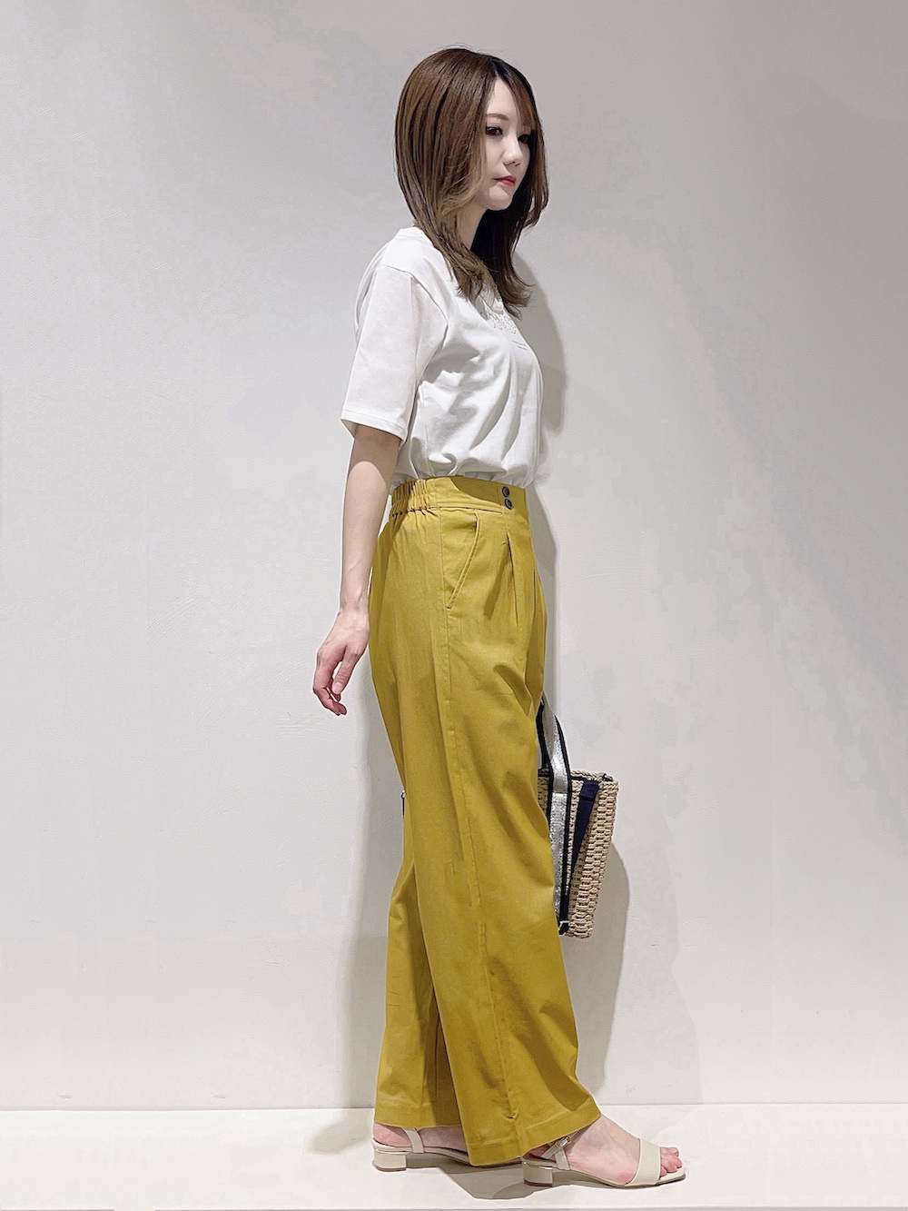 ベージュ系のトートバッグ、ブルー系のノーカラージャケット、ホワイト系のTシャツ/カットソーを着用したレディースの春コーディネートの2枚目の写真