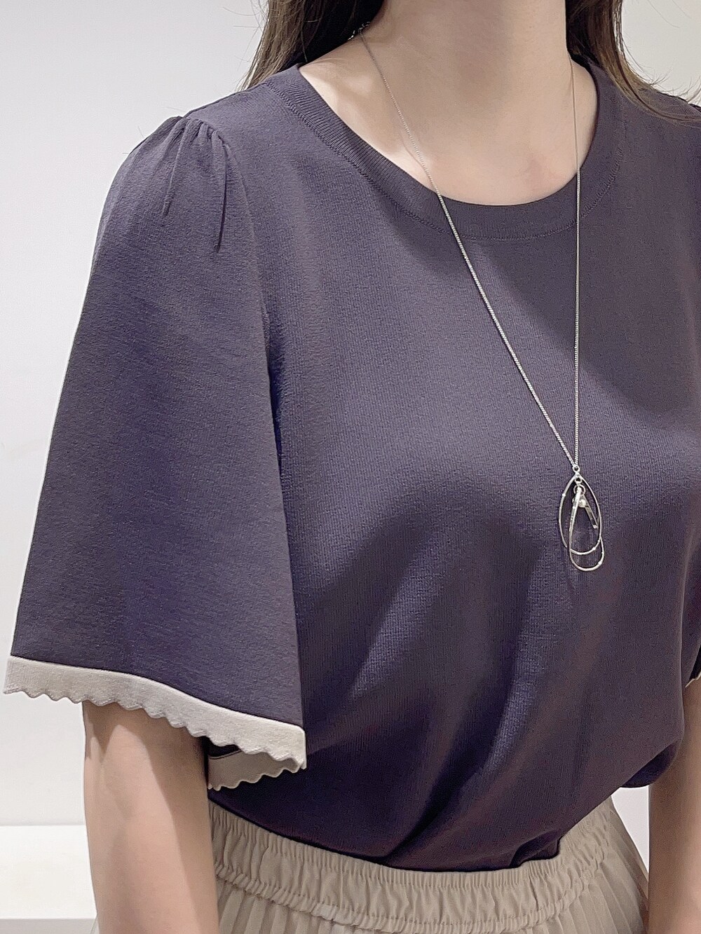 グレー系のニット/セーター、ベージュ系のスカート、ホワイト系のトートバッグを着用したレディースの夏コーディネートの5枚目の写真