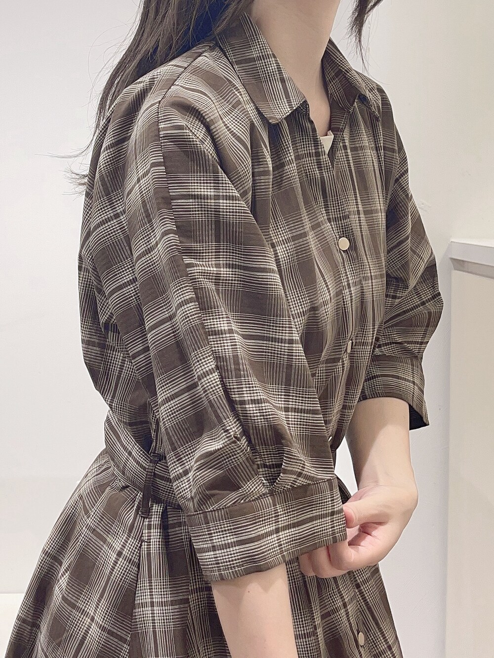 ブラウン系のワンピース、ホワイト系のTシャツ/カットソー、ベージュ系のショルダーバッグを着用したレディースの秋コーディネートの6枚目の写真
