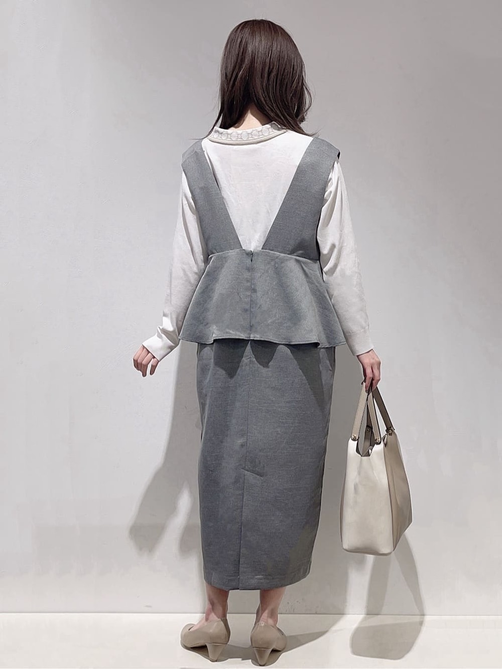 ブラウン系のニット/セーター、ベージュ系のパンプス、ベージュ系のトートバッグを着用したレディースの春コーディネートの3枚目の写真