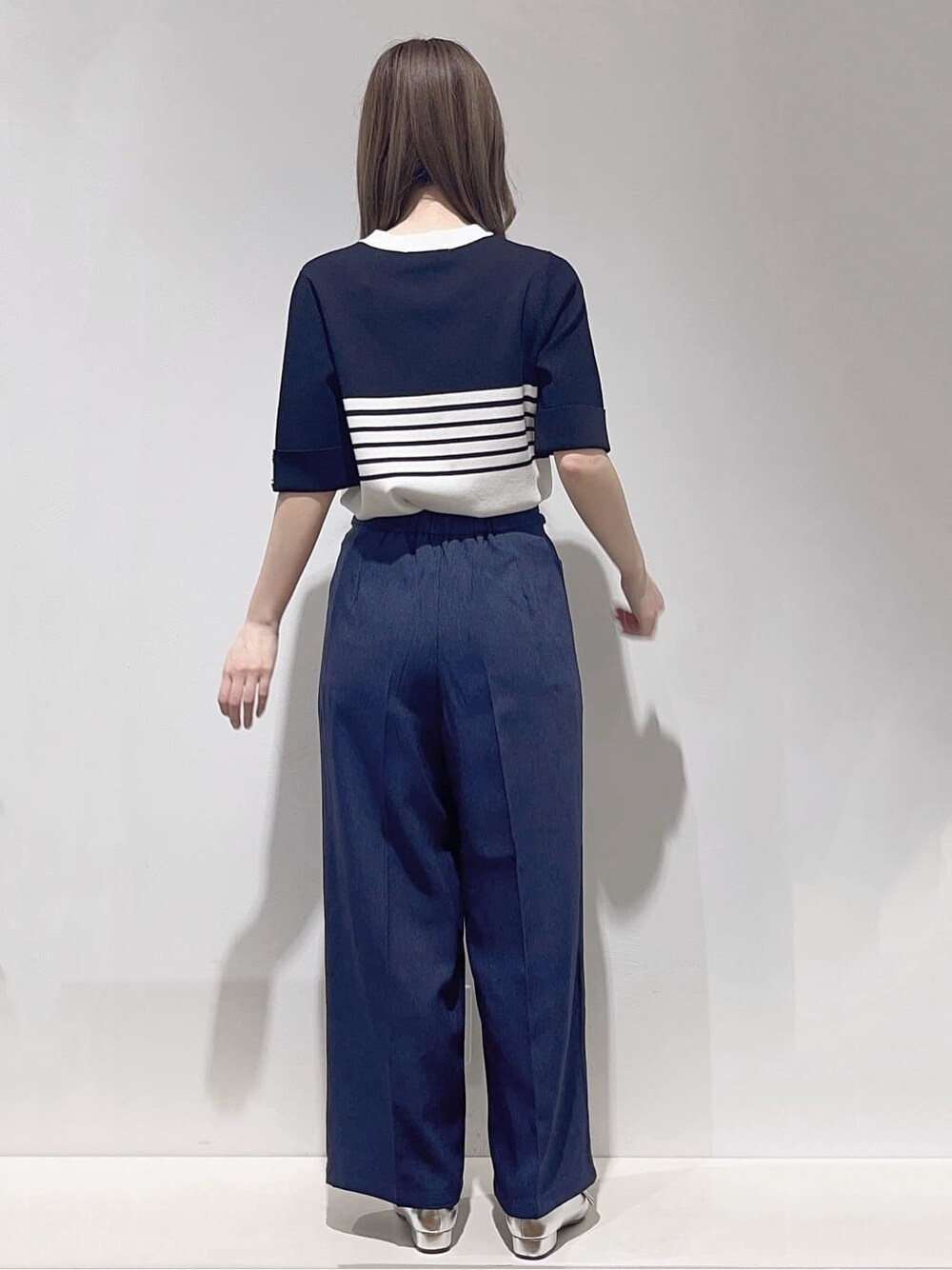 ベージュ系のトレンチコート、ブラック系のニット/セーター、ブルー系のその他パンツを着用したレディースの春コーディネートの6枚目の写真