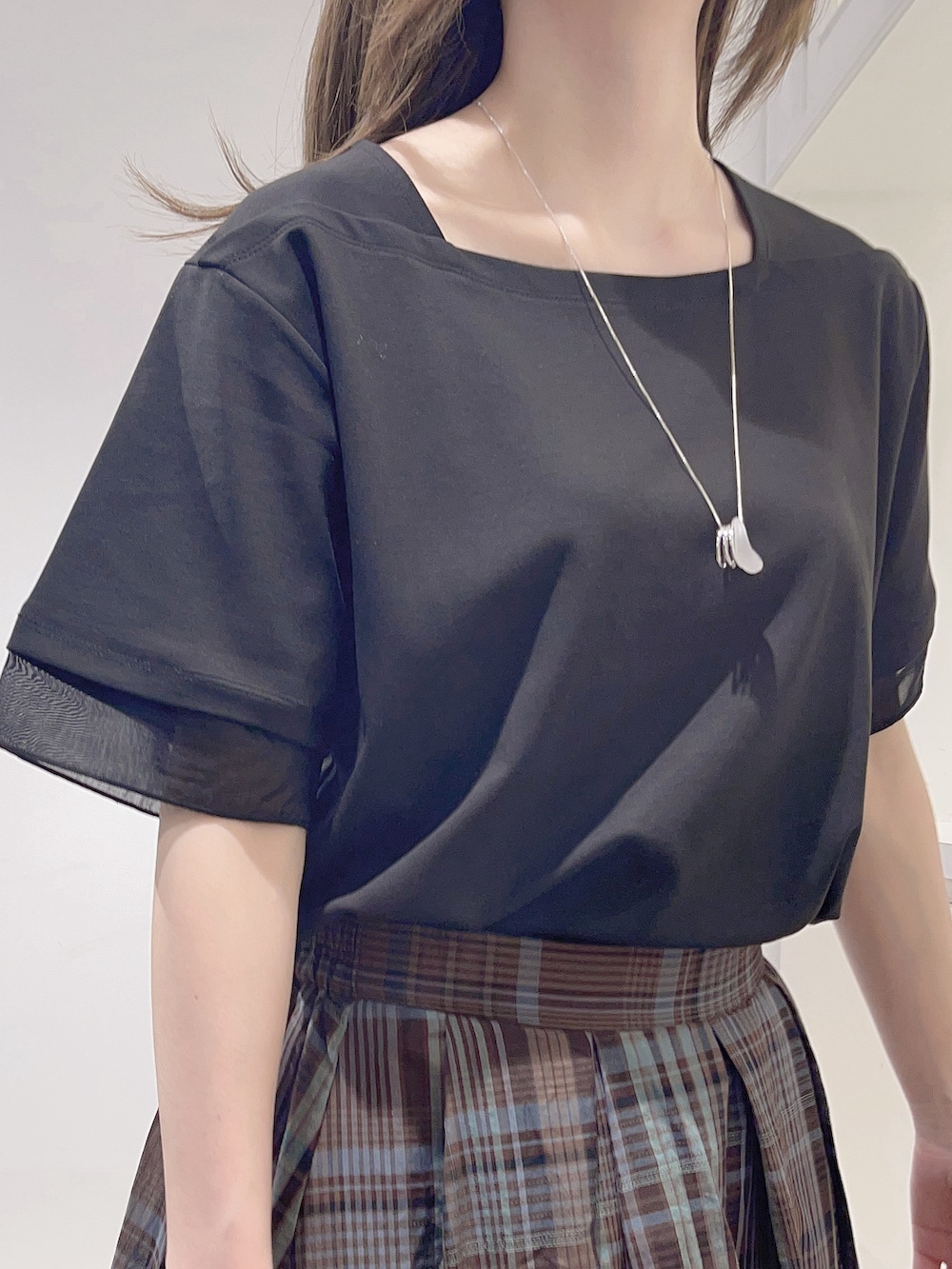 ブラック系のTシャツ/カットソー、ブラウン系のスカート、ブラック系のトートバッグを着用したレディースの春コーディネートの4枚目の写真