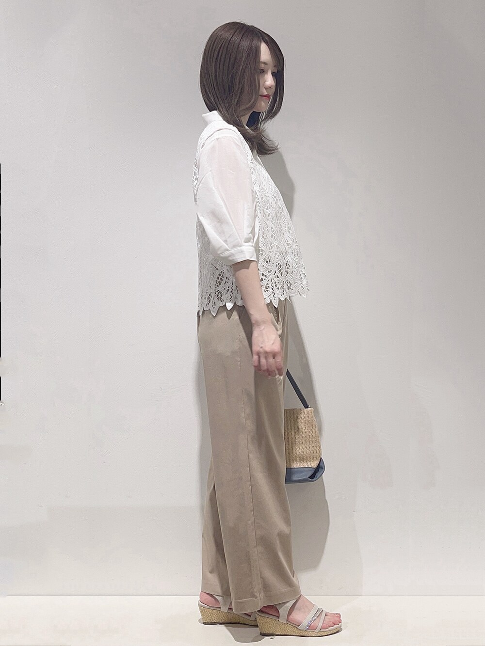 ホワイト系のシャツ/ブラウス、ベージュ系のその他パンツ、ブルー系のショルダーバッグを着用したレディースの春コーディネートの2枚目の写真