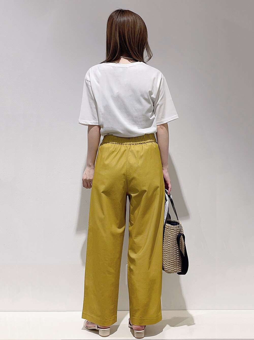 ホワイト系のTシャツ/カットソー、イエロー系のその他パンツ、ベージュ系のトートバッグを着用したレディースの春コーディネートの3枚目の写真