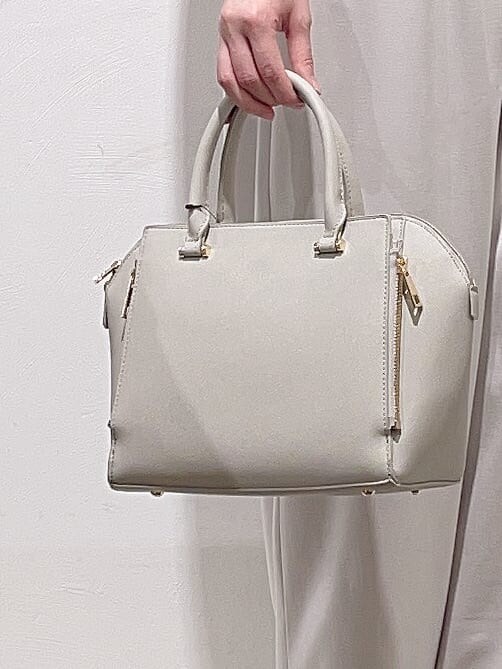 レッド系のニット/セーター、ベージュ系のその他パンツ、グレー系のトートバッグを着用したレディースの冬コーディネートの6枚目の写真