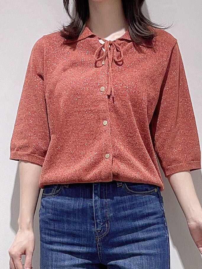 レッド系のニット/セーター、ブルー系のデニムパンツ、シルバー系のショルダーバッグを着用したレディースの秋コーディネートの5枚目の写真