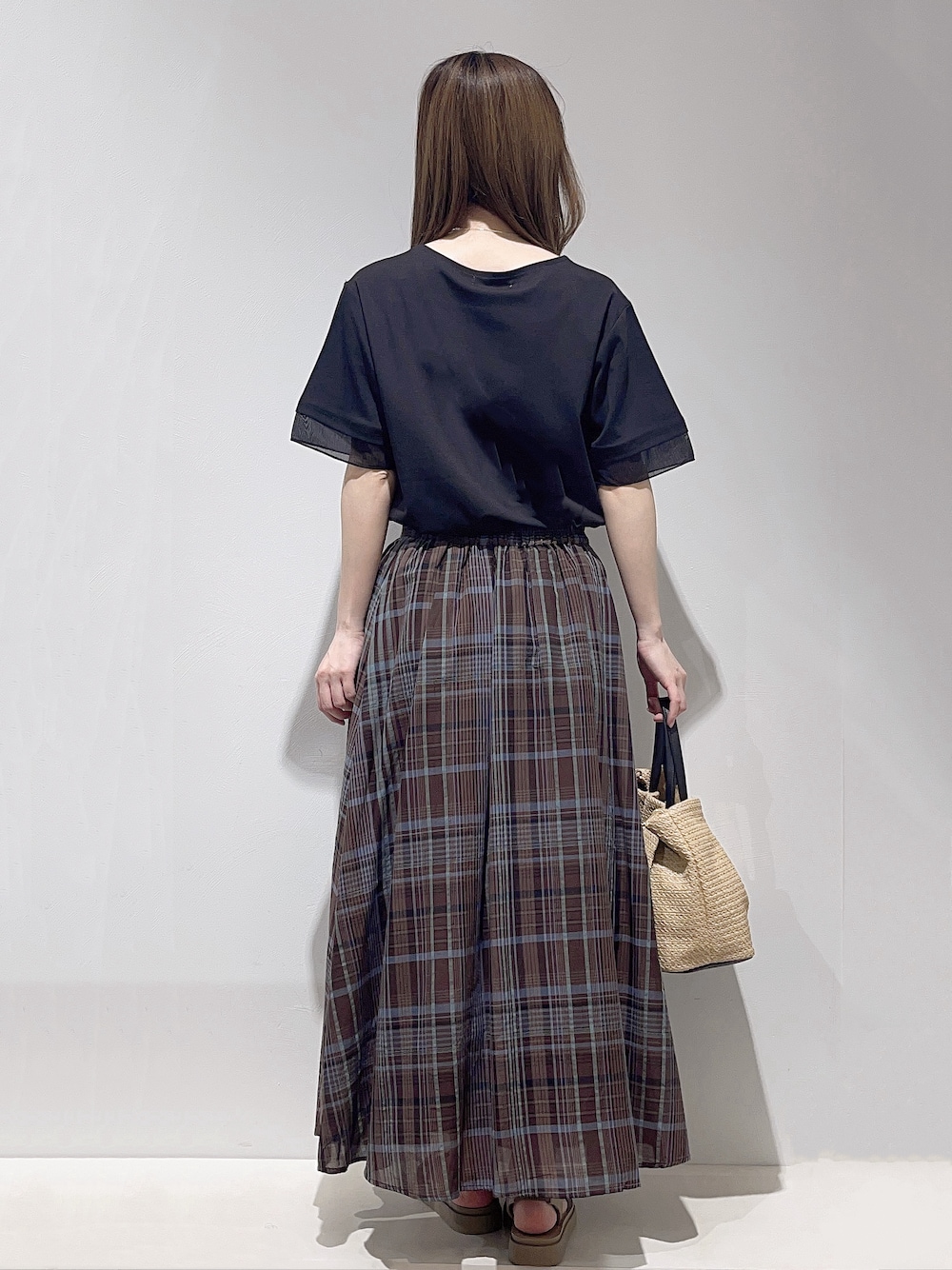 ブラック系のTシャツ/カットソー、ブラウン系のスカート、ブラック系のトートバッグを着用したレディースの春コーディネートの3枚目の写真