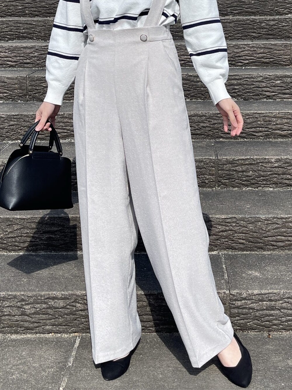 ホワイト系のニット/セーター、ベージュ系のその他パンツ、ブラック系のハンドバッグを着用したレディースの冬コーディネートの7枚目の写真
