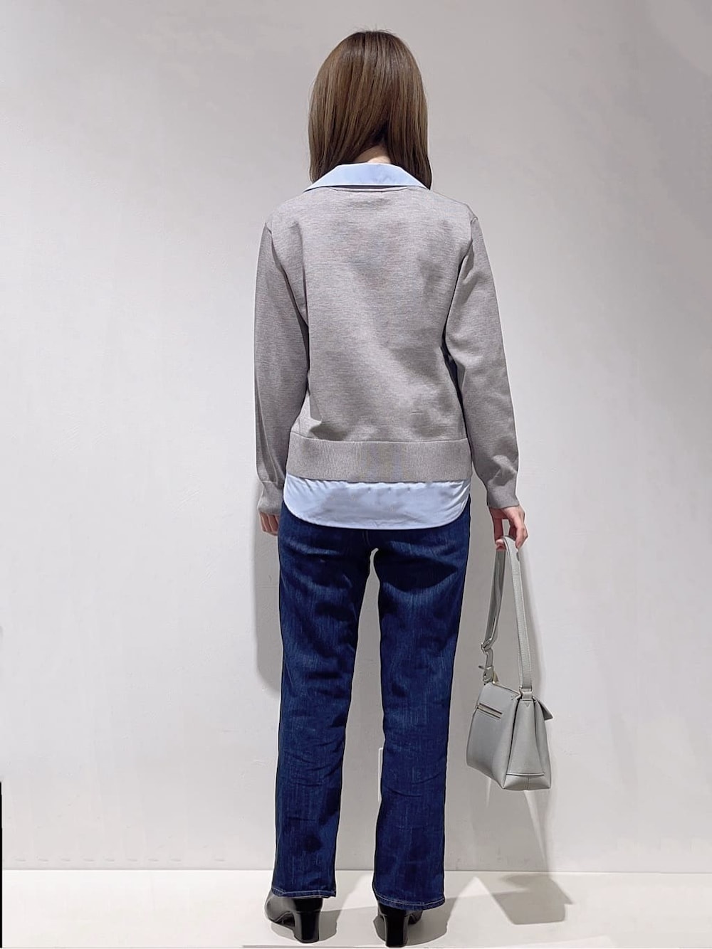 グレー系のカーディガン/ボレロ、ホワイト系のタンクトップ、ブルー系のデニムパンツを着用したレディースの冬コーディネートの3枚目の写真