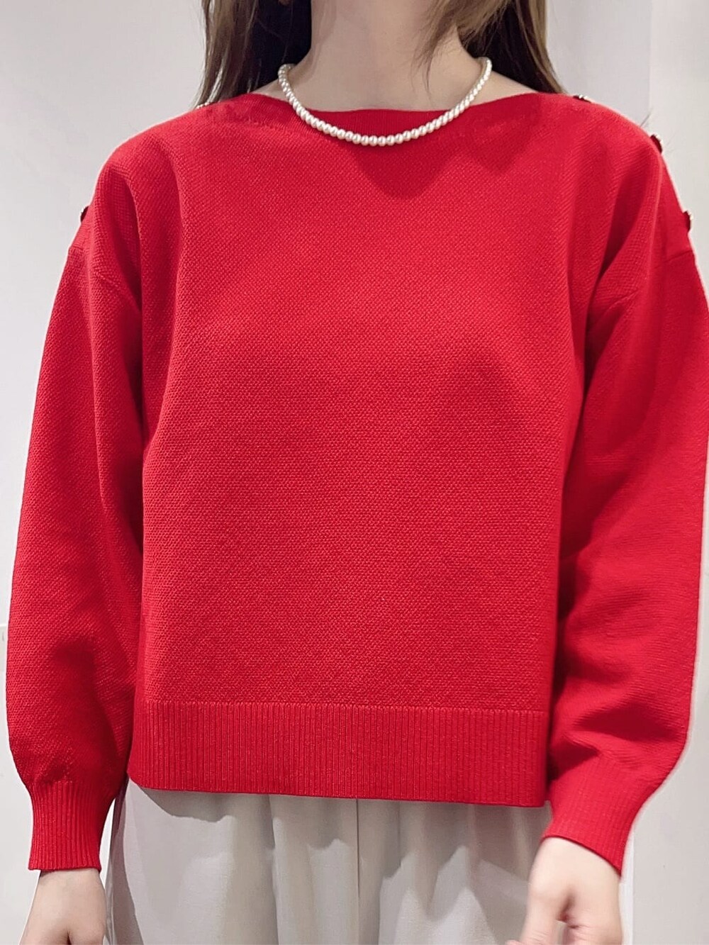 レッド系のニット/セーター、ベージュ系のその他パンツ、グレー系のトートバッグを着用したレディースの冬コーディネートの5枚目の写真