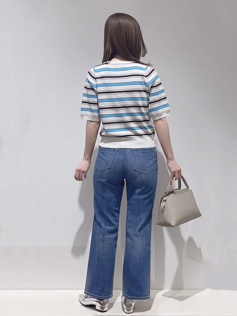 ブルー系のデニムジャケット、ブルー系のニット/セーター、ブルー系のデニムパンツを着用したレディースの春コーディネートの6枚目の写真