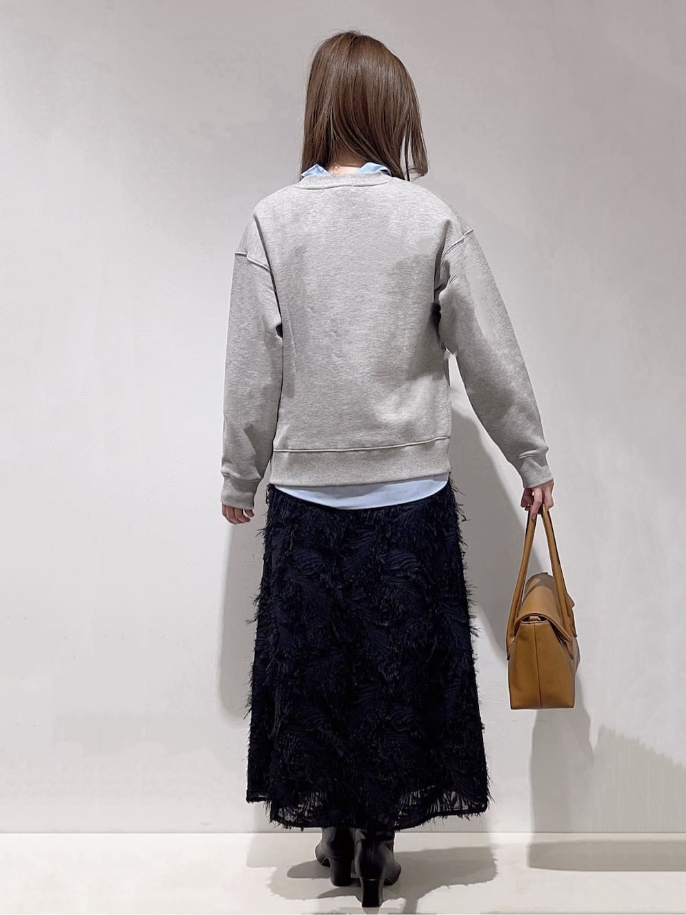 グレー系のスウェット、ブルー系のシャツ/ブラウス、ブラック系のスカートを着用したレディースの冬コーディネートの3枚目の写真