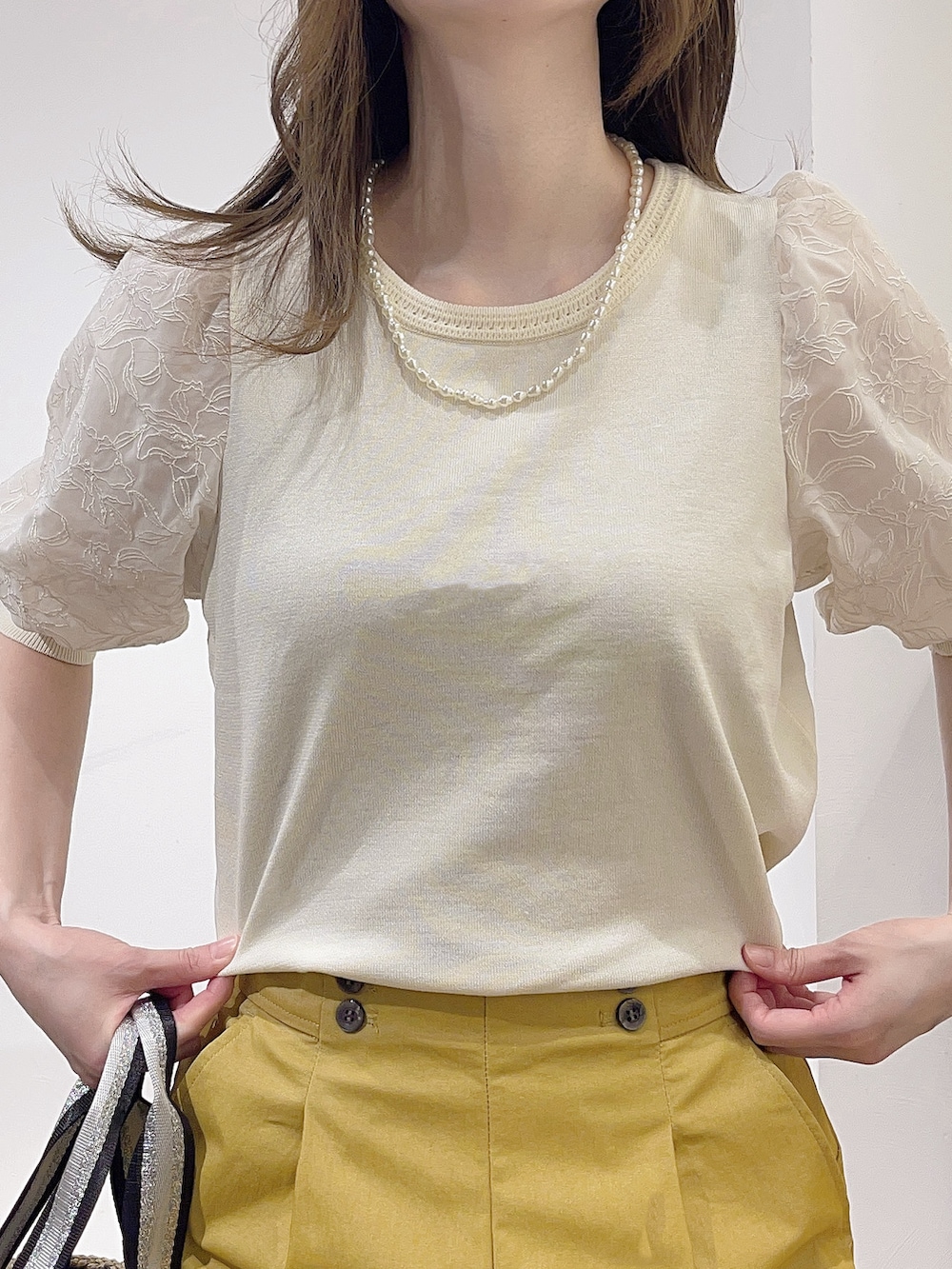 ベージュ系のトートバッグ、ホワイト系のニット/セーター、ブルー系のスカートを着用したレディースの春コーディネートの7枚目の写真